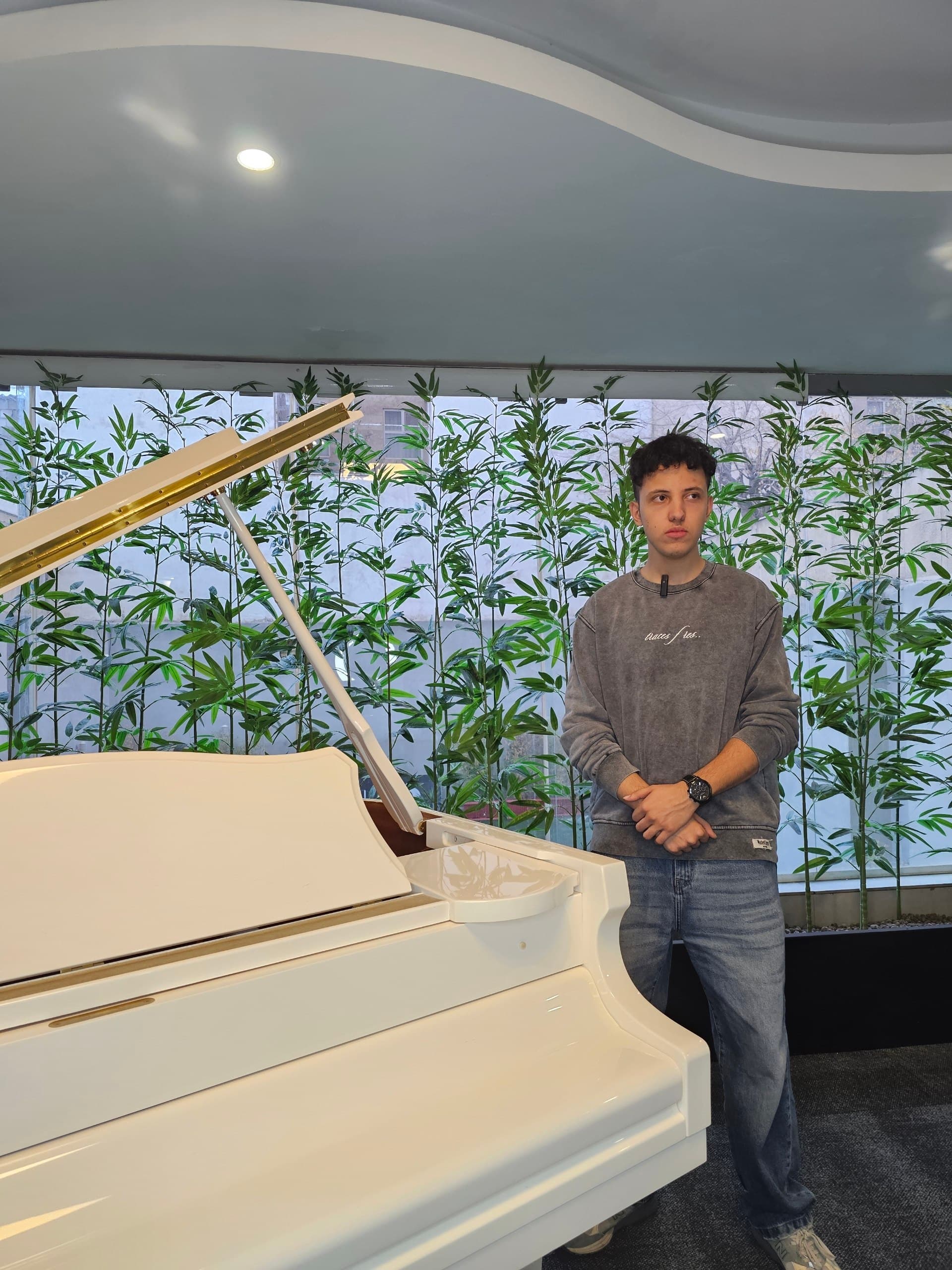 A musician beside a piano while studying composition and harmony